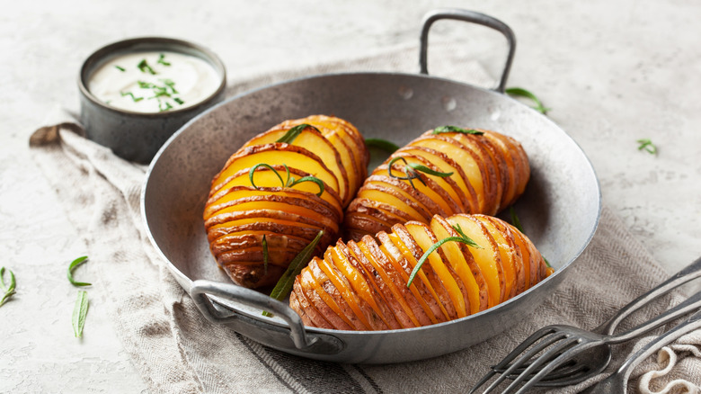 Hasselback potatoes with rosemary in a metal dish