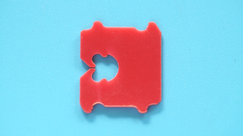 A red bread tag is in focus on a turquoise background