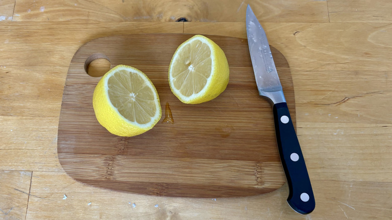 Lemon cut in half on cutting board