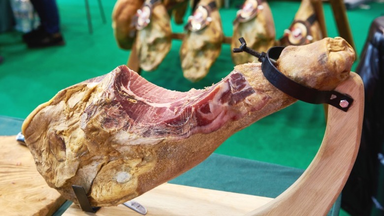 A leg of Jamón Serrano on a wooden stand.