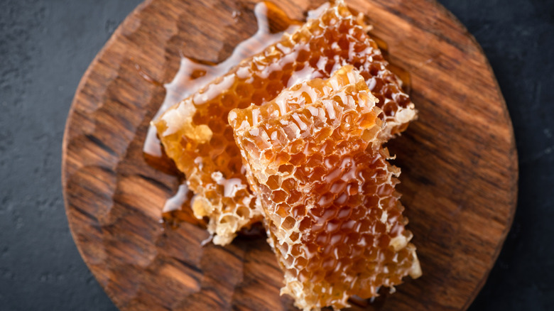 Two slabs of honeycomb on wooden board