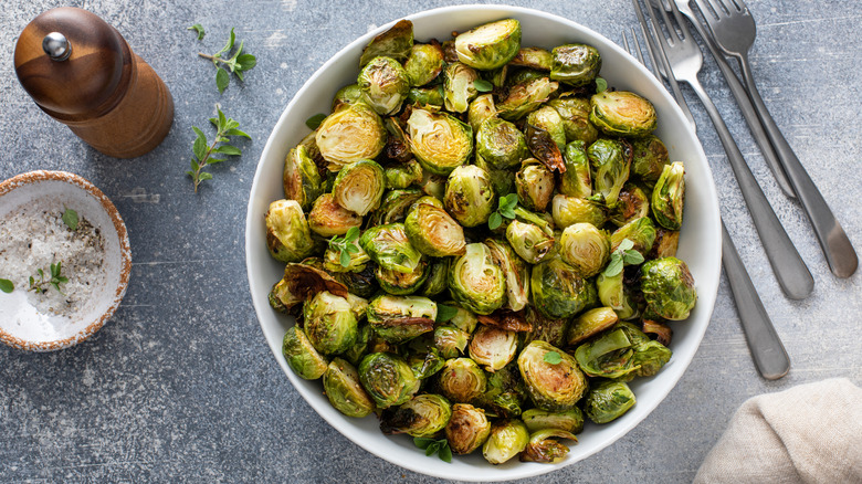 Crispy Brussels sprouts in a bowl with salt on side