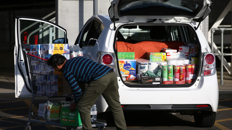 man loading car with groceries