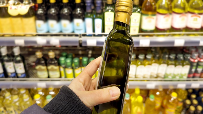 Holding a bottle of olive oil in the store