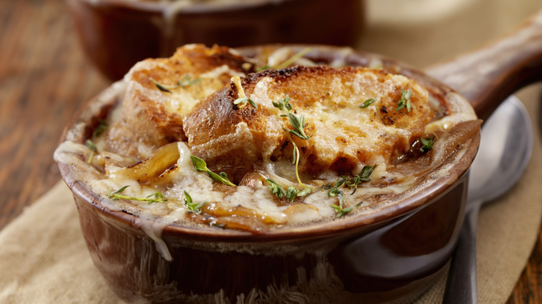 French onion soup in a brown bowl.