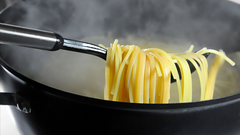 Close up shot of spaghetti pasta taken from boiling water in a pot