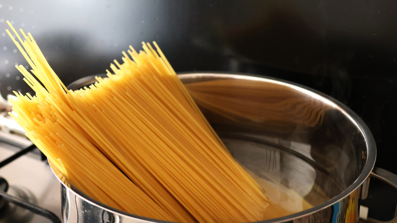 dried spaghetti pasta cooking in a pot