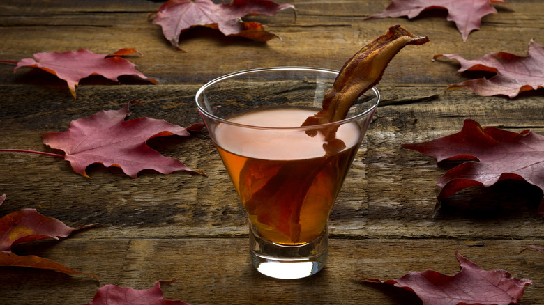 A slab of maple bacon in a glass of whisky