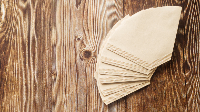 Brown paper coffee filters on wooden table