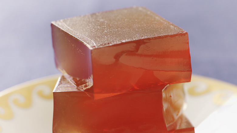 A close-up photo of square, orange jell-o shots in a pile