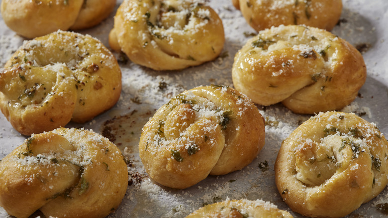 garlic knots with parmesan and parsley on parchment paper