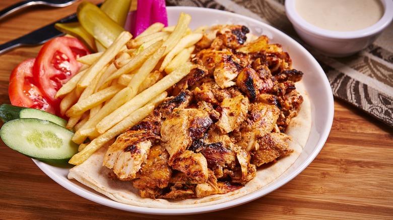 chicken shawarma on plate with fries and salad