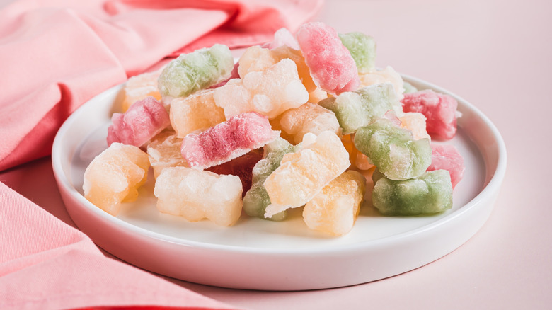 A plate of frozen gummy bears on a white plate with a pink napkin