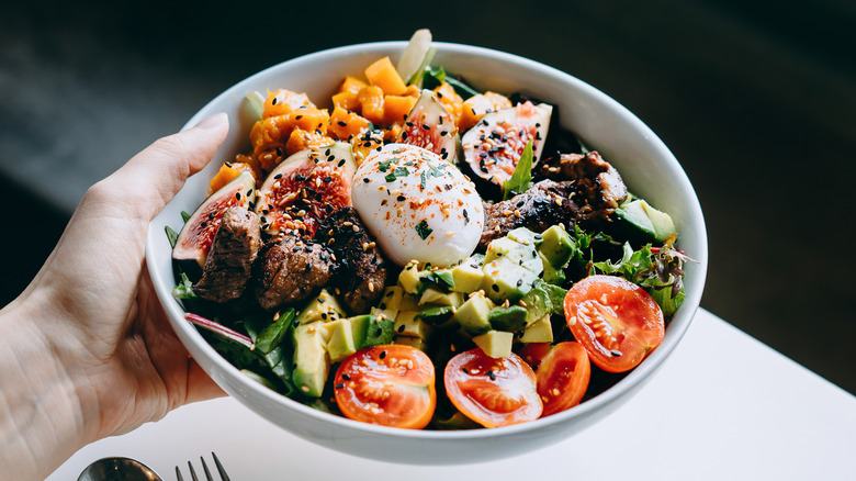 Woman's hand holding salad