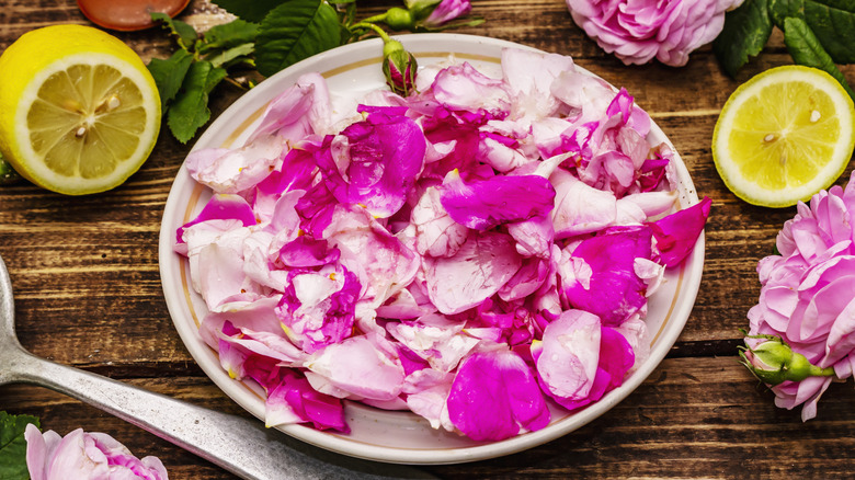 A plate of rose petals with lemons and a spoon