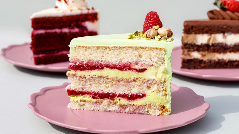 Three cake slices on pink plates