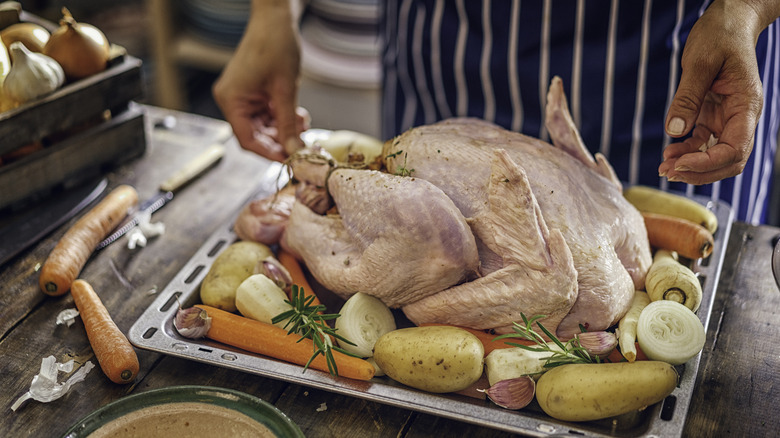 A raw whole turkey being prepared for dinner