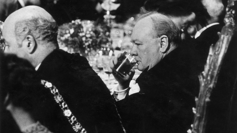 Winston Churchill drinking at a dinner