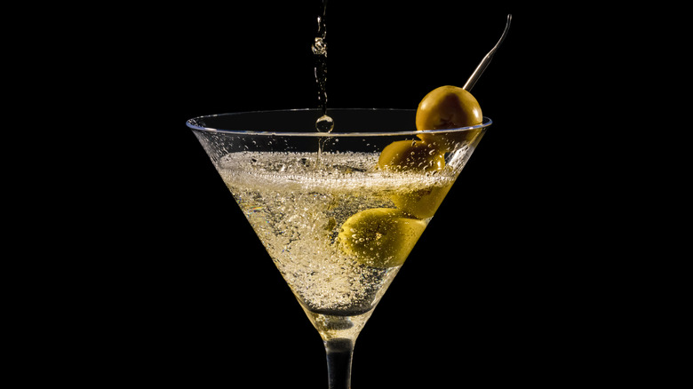 A glass of martini with olive