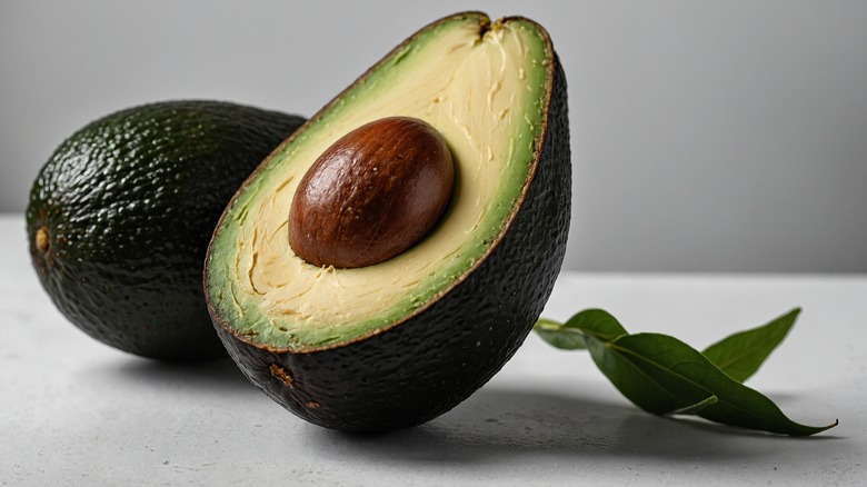 halved avocado in front of whole one