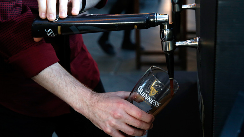 A man pours Guinness from a branded tap