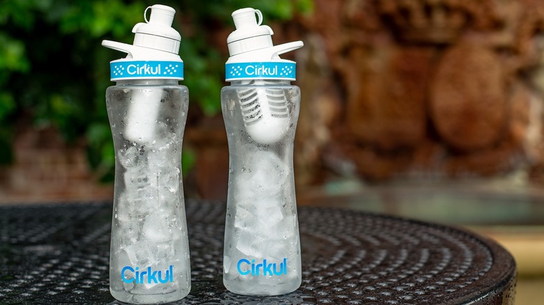 Two clear Cirkul water bottles with ice on an outdoor table