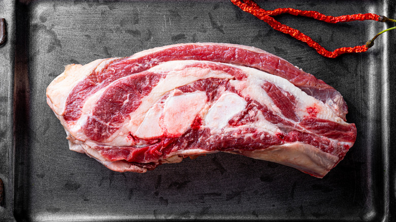 A raw beef brisket on a baking sheet