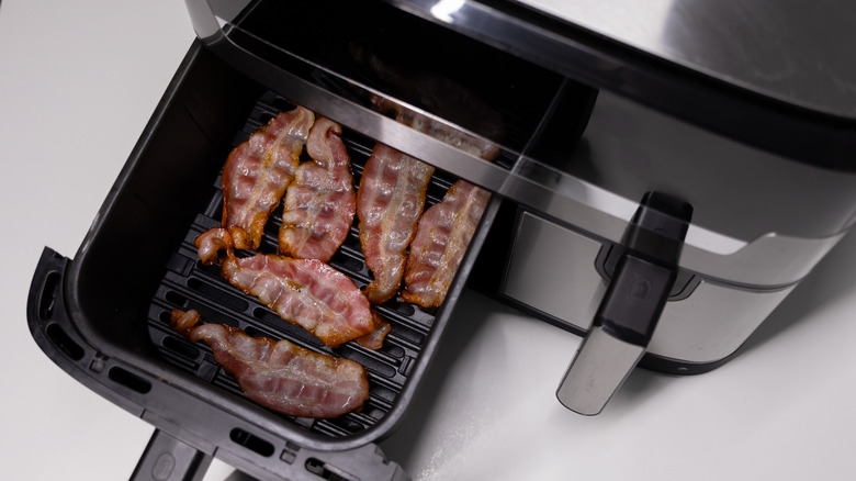 Bacon strips cooking in an air fryer