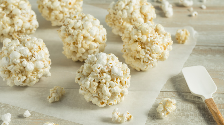 Popcorn balls on wax paper with a white rubber spatula