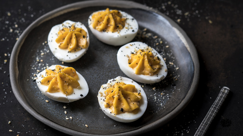 A black plate covered with deviled eggs.