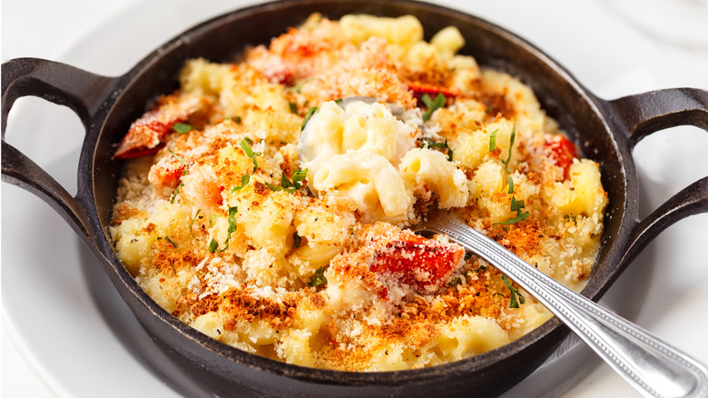 Black skillet full of lobster mac and cheese with spoon