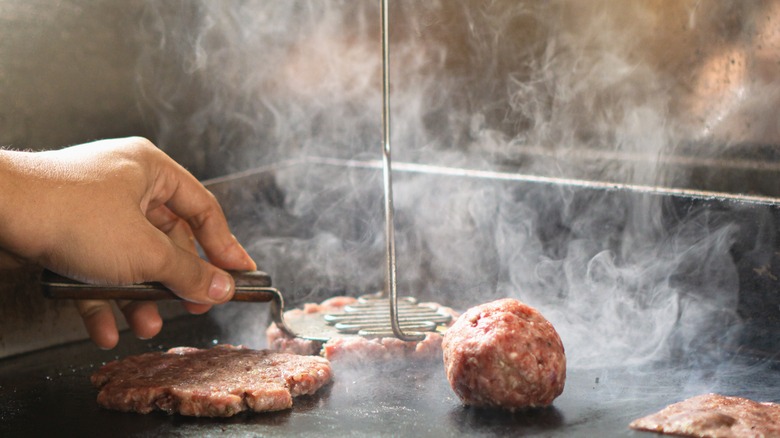 Smashed burger patties on a heated griddle