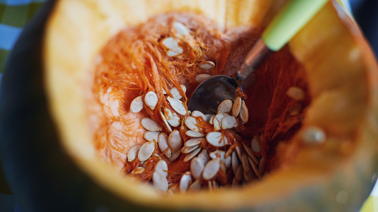 a pumpkin cut open to reveal the seeds and pulp inside