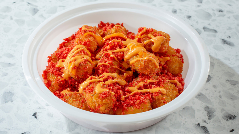 Tater tots drenched in spicy sauces.