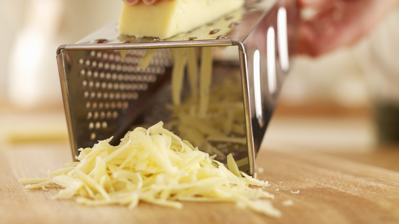 Cheese being shredded on a grater