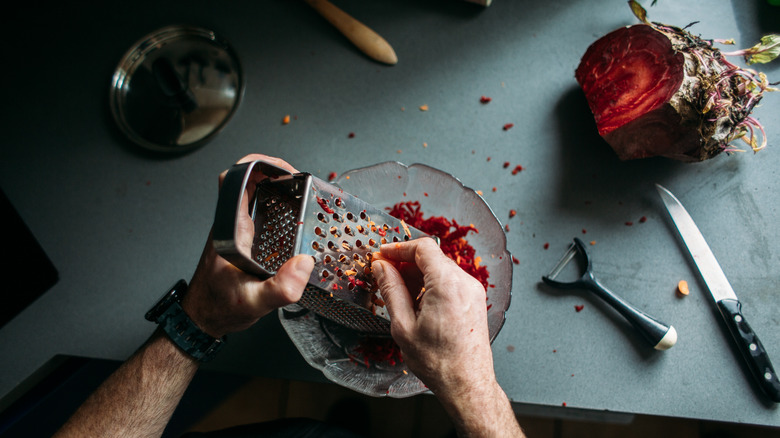 A man grating veggies into a bowl