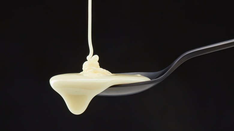 condensed milk pouring onto spoon