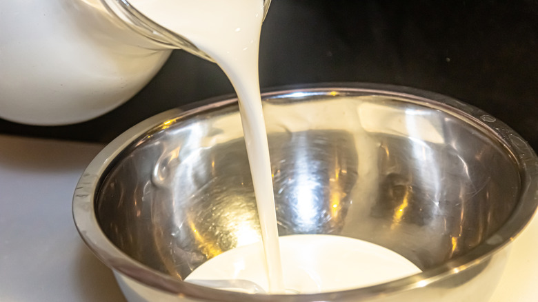 a pitcher of heavy cream being poured into a bowl