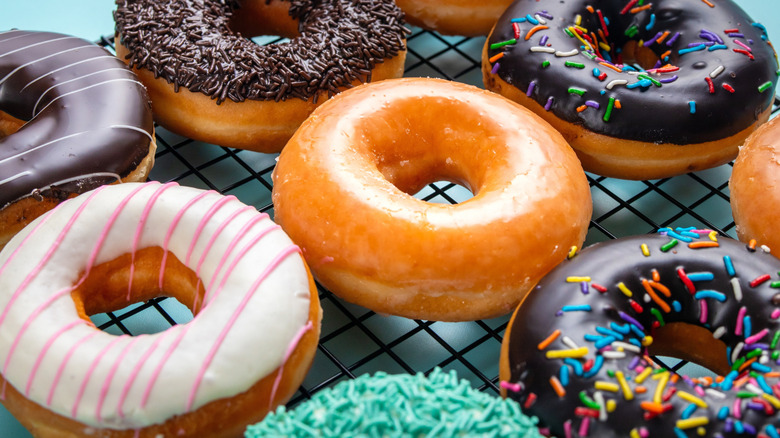 A wire rack loaded with chocolate and glazed yeast donuts