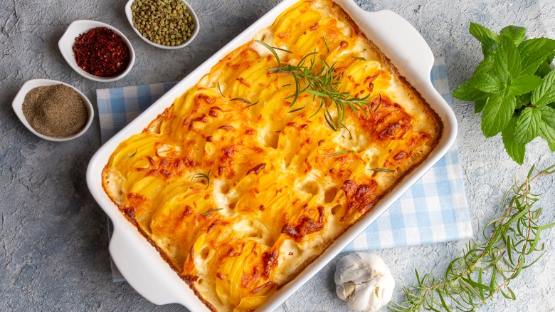 A dish of scalloped potatoes topped with herbs