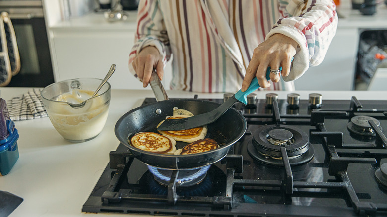 A person cooking pancakes on the stovetop