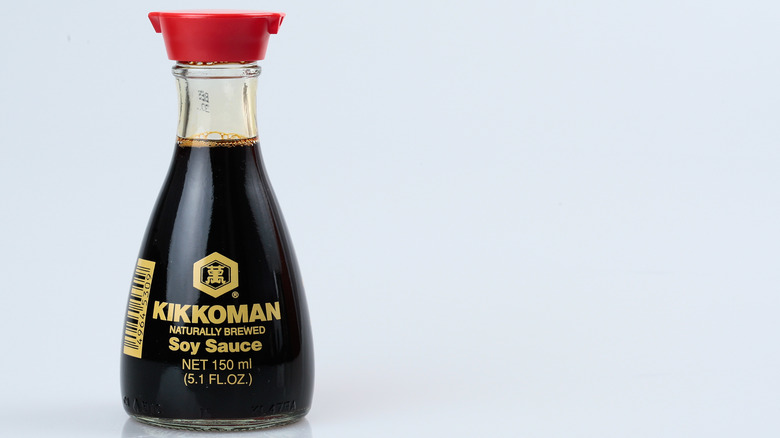 A small bottle of Kikkoman soy sauce with a red, double spouted cap.