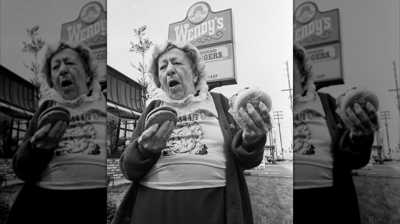 Clara Peller holding hamburgers oustide a Wendy's