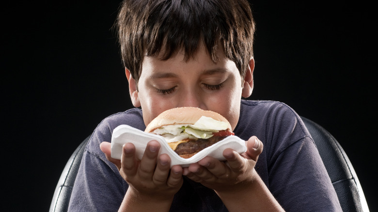 boy smelling burger