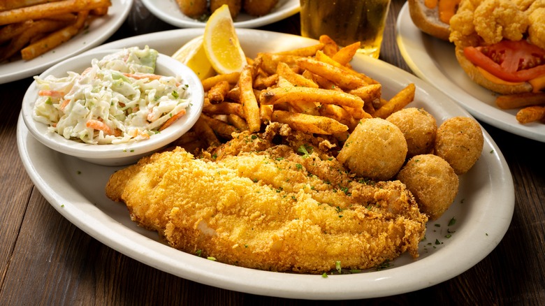 Plate of fried fish, hushpuppies, slaw, and fries