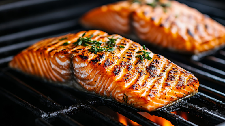 Two pieces of salmon cooking on the grill