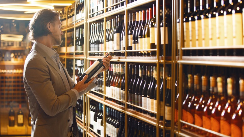 Man wine store looking at bottle