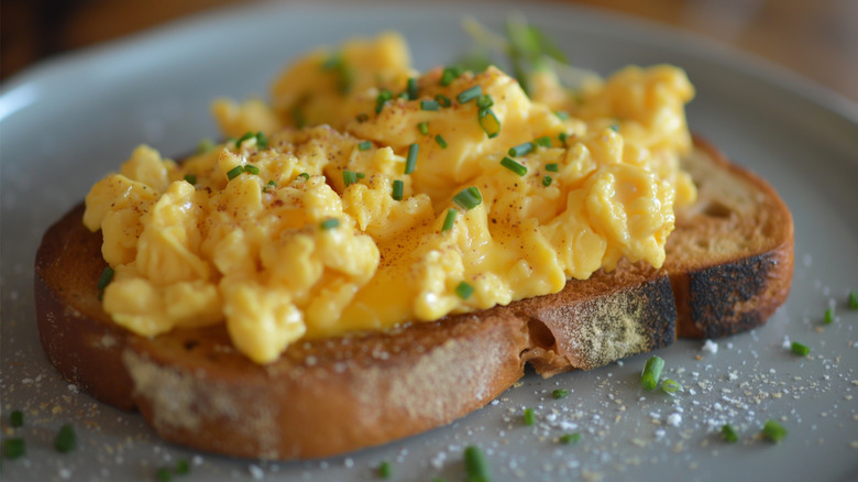 Scrambled eggs with chives on toasted bread