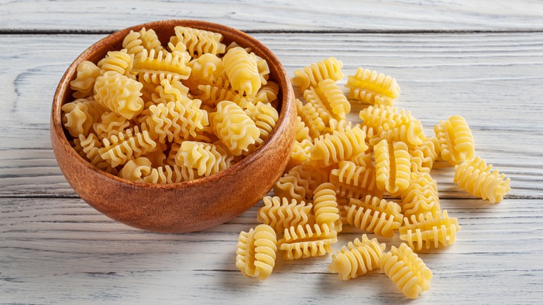 A wooden bowl of dry radiatori pasta