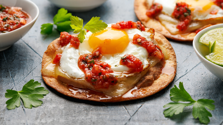 Huevos rancheros with a fried egg topped with spicy red sauce